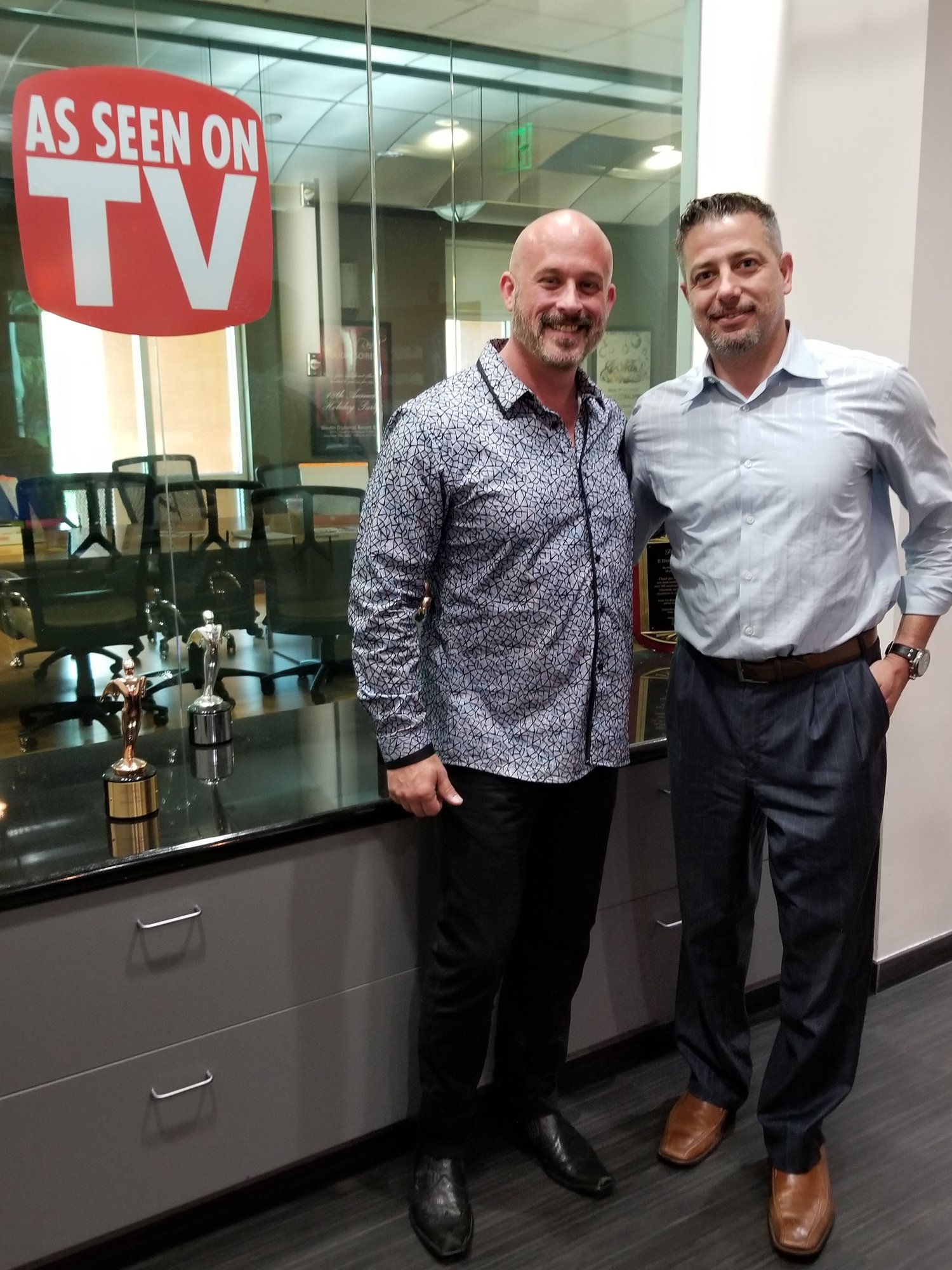 Spotlight Media founder with entrepreneur Harrison beside his award shelf