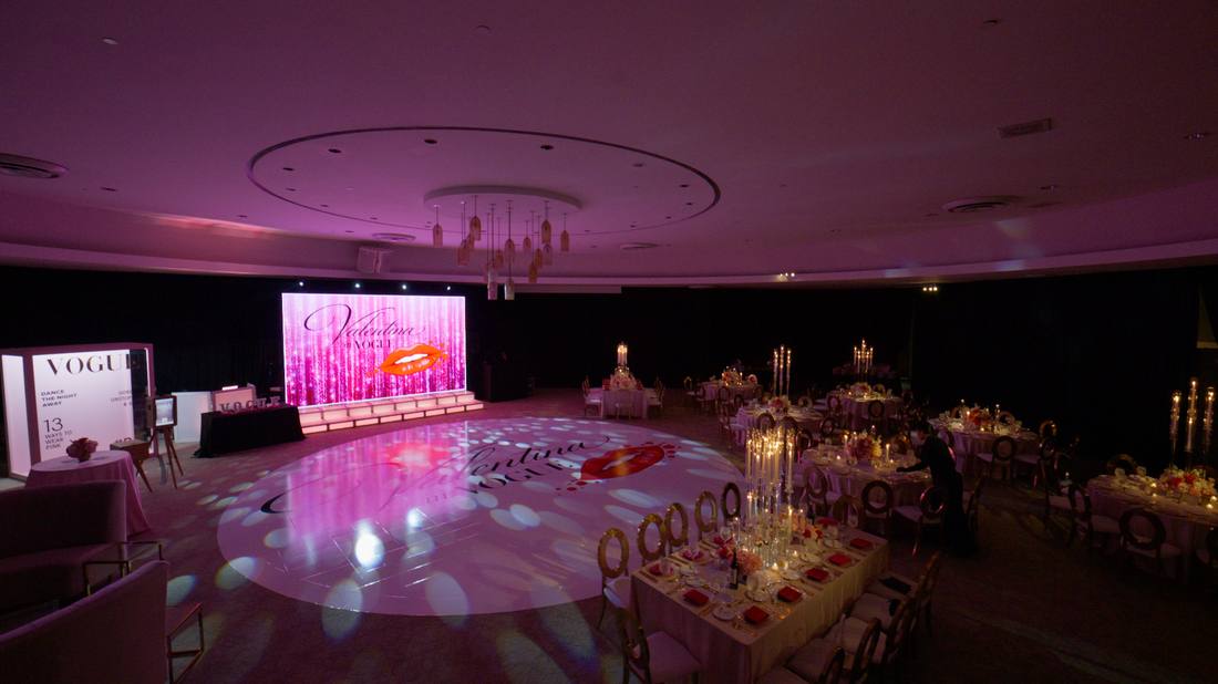 Ballroom reception space with a lit dance floor and elegant table settings