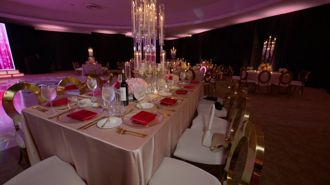 Elegant reception table set with gold chairs and tall candle arrangements